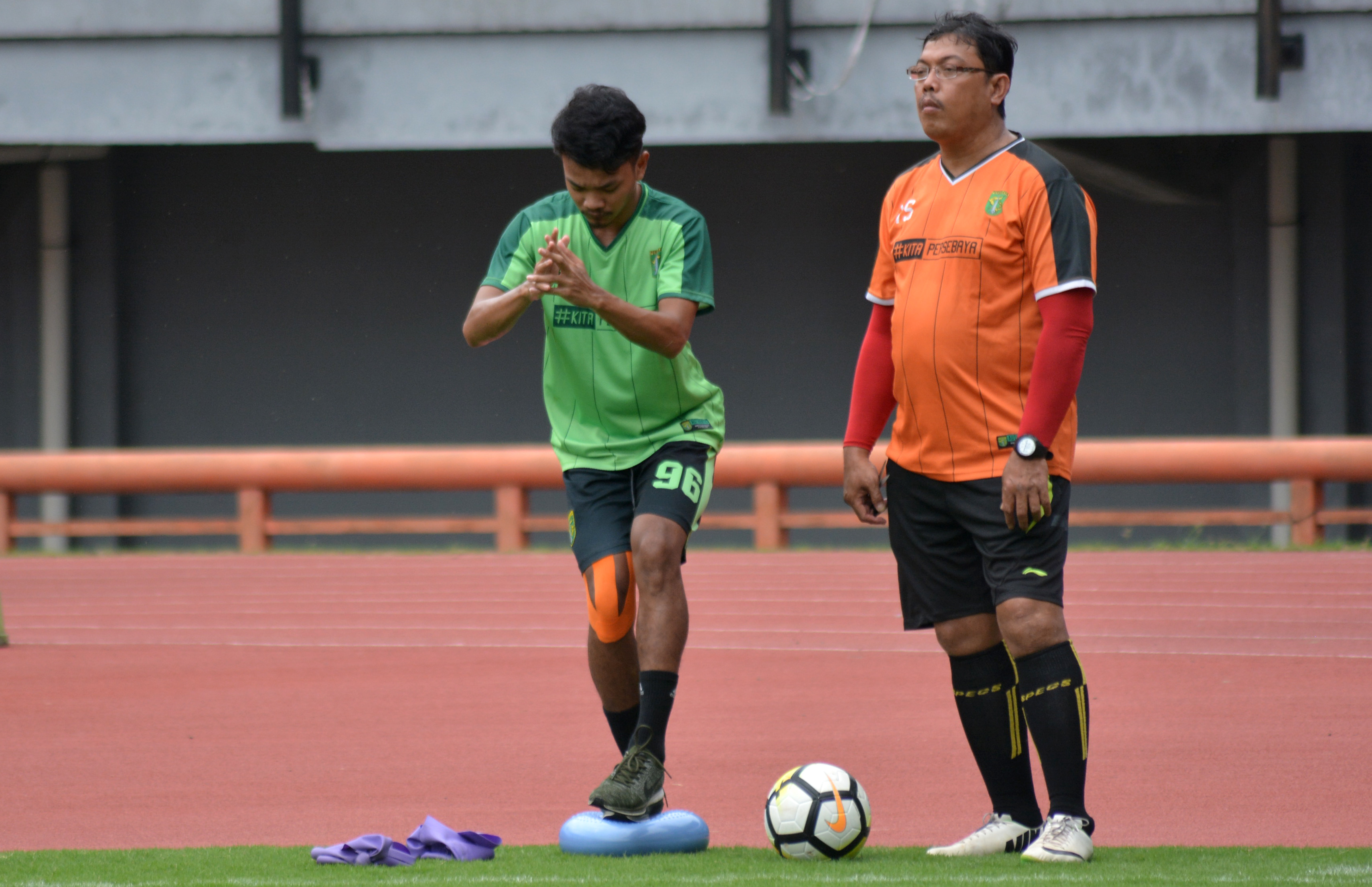 Pemain Persebaya M. Hidayat (hijau) saat menjalani terapi dengan didampingi tim dokter. (foto: hrs/ngopibareng)