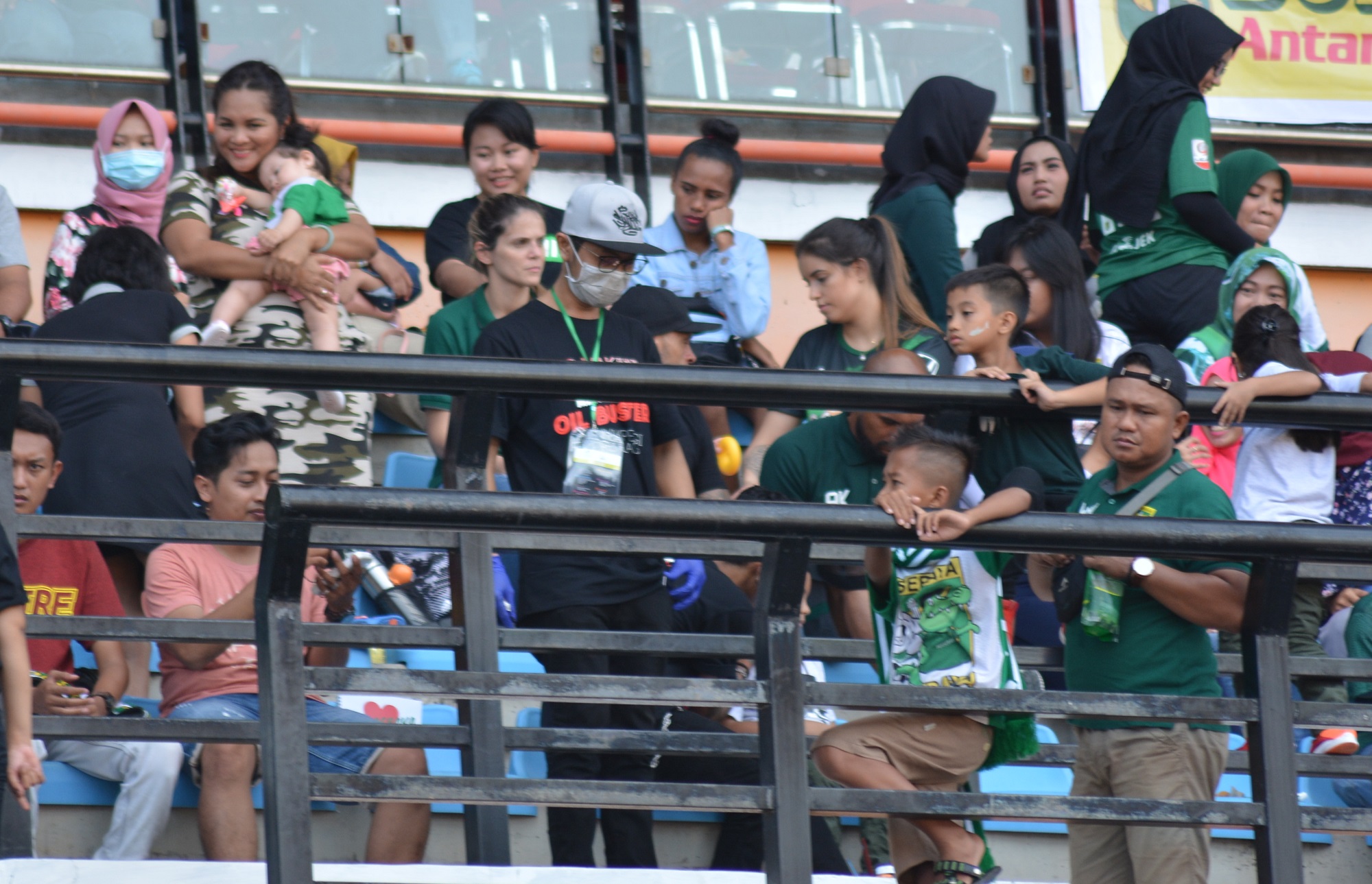 Suporter yang menyaksikan pertandingan Persebaya vs Barito Putra mengenakan masker karena terganggu dengan aroma sampah di Stadion GBT. (foto: hrs/ngopibareng)