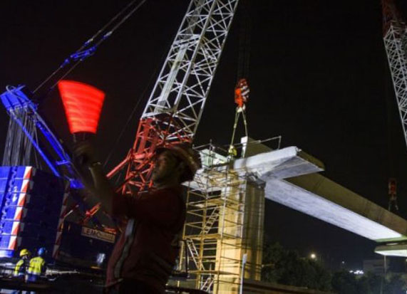 Pekerja dengan alat berat memasang U-Shape saat pembangunan light rail transit (LRT) di Jalan Rasuna Said, Kuningan, Jakarta, Rabu 14 Maret 2018 dini hari. (Foto: Antara)