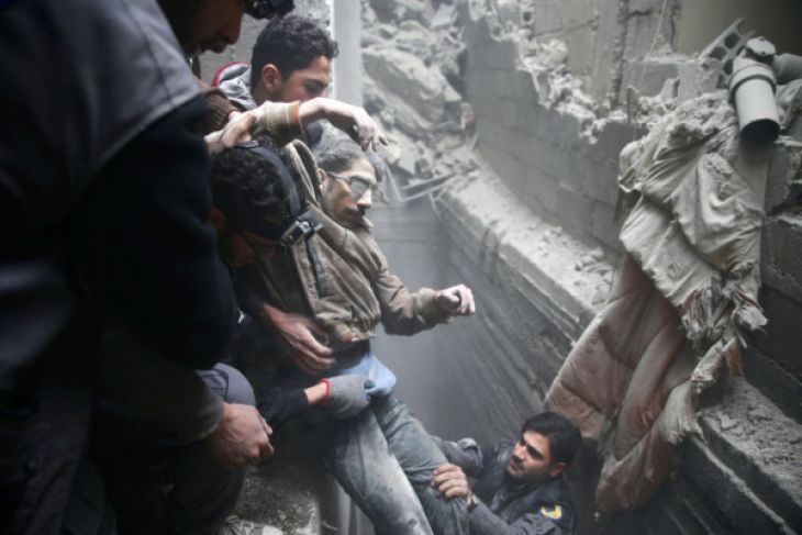 Penduduk sipil menolong seorang pria dari sebuah tempat berlindung di Kota Douma yang terkepung di Ghouta Timur, Damaskus, Suriah, Kamis (22/2/2018). (Foto: REUTERS/BASSAM KHABIEH)