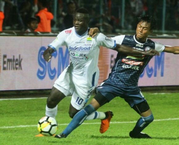 Pesepakbola Persib Bandung, Ezechiel Ndouasel (kiri) berebut bola dengan pesepakbola Arema FC, Johan Al Farisyi (kanan) dalam pertandingan GO-JEK Liga I di Stadion Kanjuruhan, Malang, Jawa Timur, Minggu 15 April 2018. Skor di akhir babak pertama 1-1. (Foto: Antara)