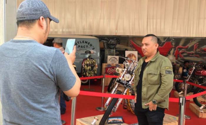Pengunjung berfoto di depan motor modifikasi gaya chopperland merek Royal Enfield 350 cc milik Presiden Joko Widodo yang dipajang pada ajang Indonesia International Motor Show (IIMS) 2018. (foto:sella panduarsa gareta/antara)