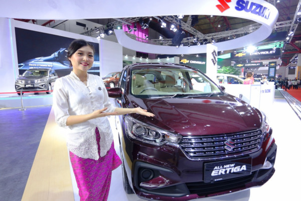 Model berkebaya berpose di sisi All New Ertiga pada pameran IIMS 2018. (Foto: Antara)