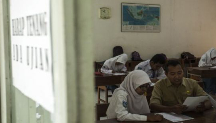 Petugas membantu membacakan soal ujian kepada pelajar penyandang low vision saat Ujian Nasional (UN) tingkat SMA Sederajat di Sekolah Luar Biasa (SLB) Negeri 1 Bantul, DI Yogyakarta, Senin (9/4/2018). Menurut data Kemendikbud tercatat jumlah peserta UN SMA sederajat di Indonesia tahun 2018 sebanyak 1.983.568 peserta dari 21.143 satuan pendidikan. (Foto: Antara)