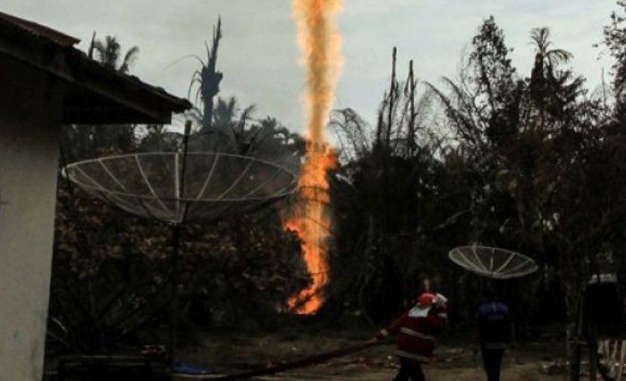 Petugas pemadam kebakaran berupaya memadamkan kebakaran sumur pengeboran minyak ilegal di Dusun Kamar Dingin Desa Pasir Putih, Ranto Panjang Peureulak, Kabupaten Aceh Timur, Aceh, Rabu 25 April 2018. Terbakarnya sumur minyak iIegal itu mengakibatkan belasan orang terluka dan 19 orang meninggal dunia. (Foto: Antara)