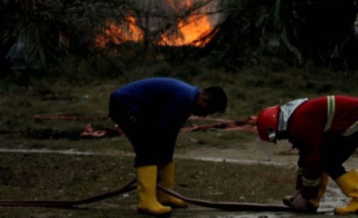 Petugas pemadam kebakaran berupaya memadamkan kebakaran sumur pengeboran minyak illegal di Dusun Kamar Dingin Desa Pasir Putih, Ranto Panjang Peureulak, Kabupaten Aceh Timur, Aceh, Rabu 25 April. Terbakarnya sumur minyak Ilegal itu mengakibatkan puluhan orang terluka dan meninggal dunia. (Foto: Antara)