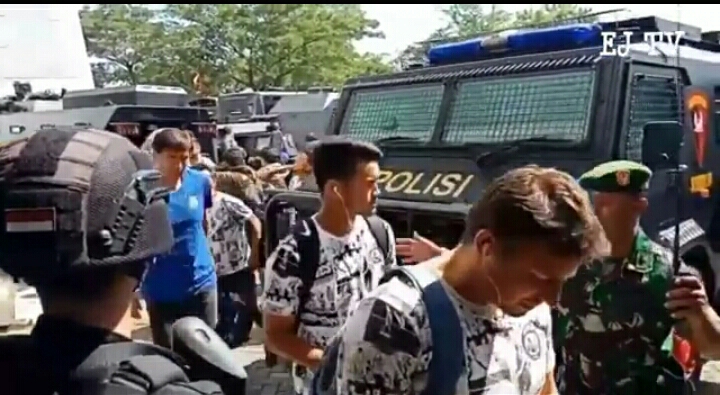 Pemain Arema satu persatu keluar dari mobil rantis di depan Stadion GBT. 