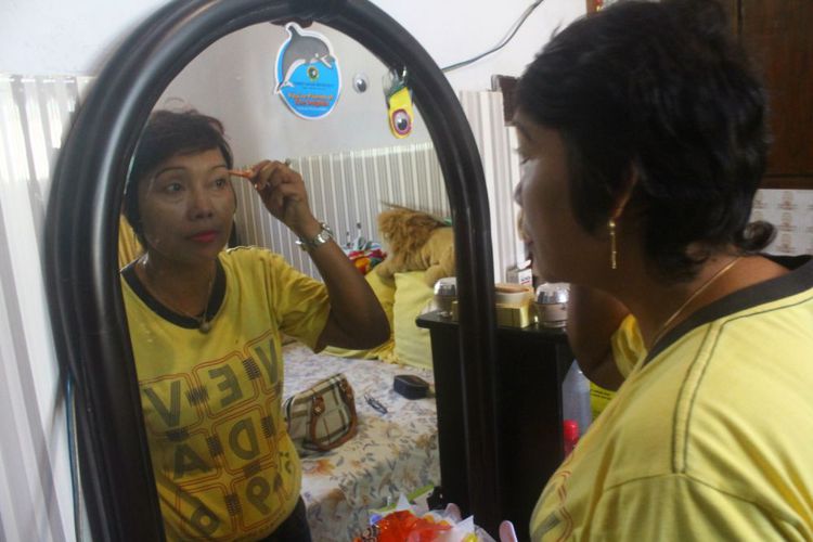 Imah Suswanti berdandan sebelum berangkat kerja,