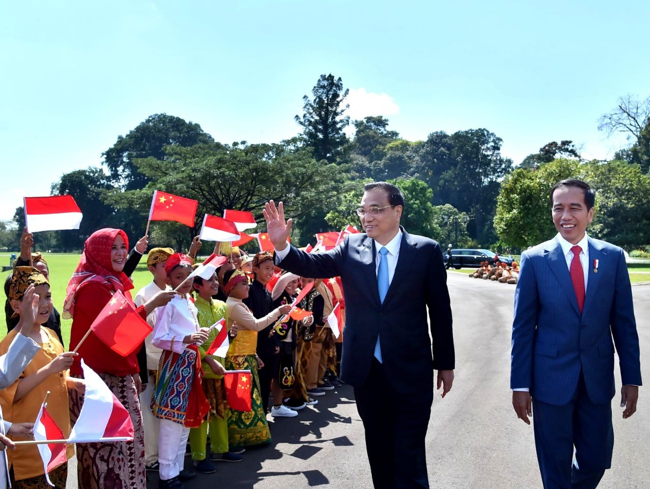 Tampak PM Li menyapa melambaikan tangannya di tengah anak-anak yang menyambutnya 