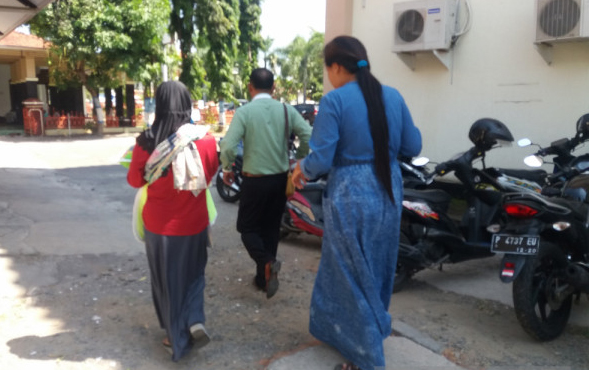 Korban EM bersama ibunya berjalan menuju SPKT Polres Situbondo. Senin, 7 Mei 2018 (Foto: Antara) 