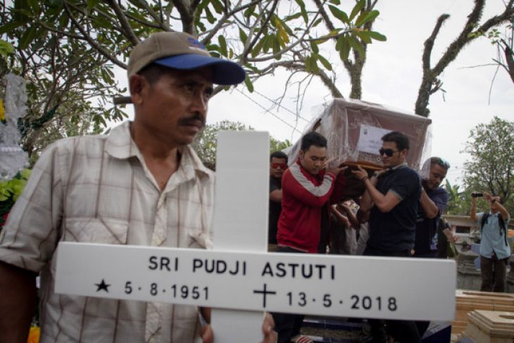 Keluarga beserta kerabat mengangkat peti jenazah, Sri Pujiastuti korban bom Surabaya untuk dimakamkan di TPU Bonoloyo, Solo, Jawa Tengah, Selasa (15/5/2018). Sri Pujiastuti merupakan salah satu korban meninggal akibat ledakan bom di Gereja Pantekosta Pusat Surabaya (GPPS) pada Minggu 13 Mei 2018 lalu. (Foto: Antara)