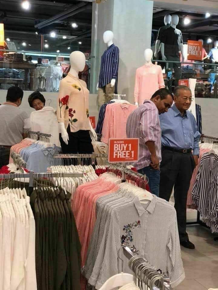 Mahathir Mohamad beserta istri tampak melihat-lihat baju diskonan tersebut.