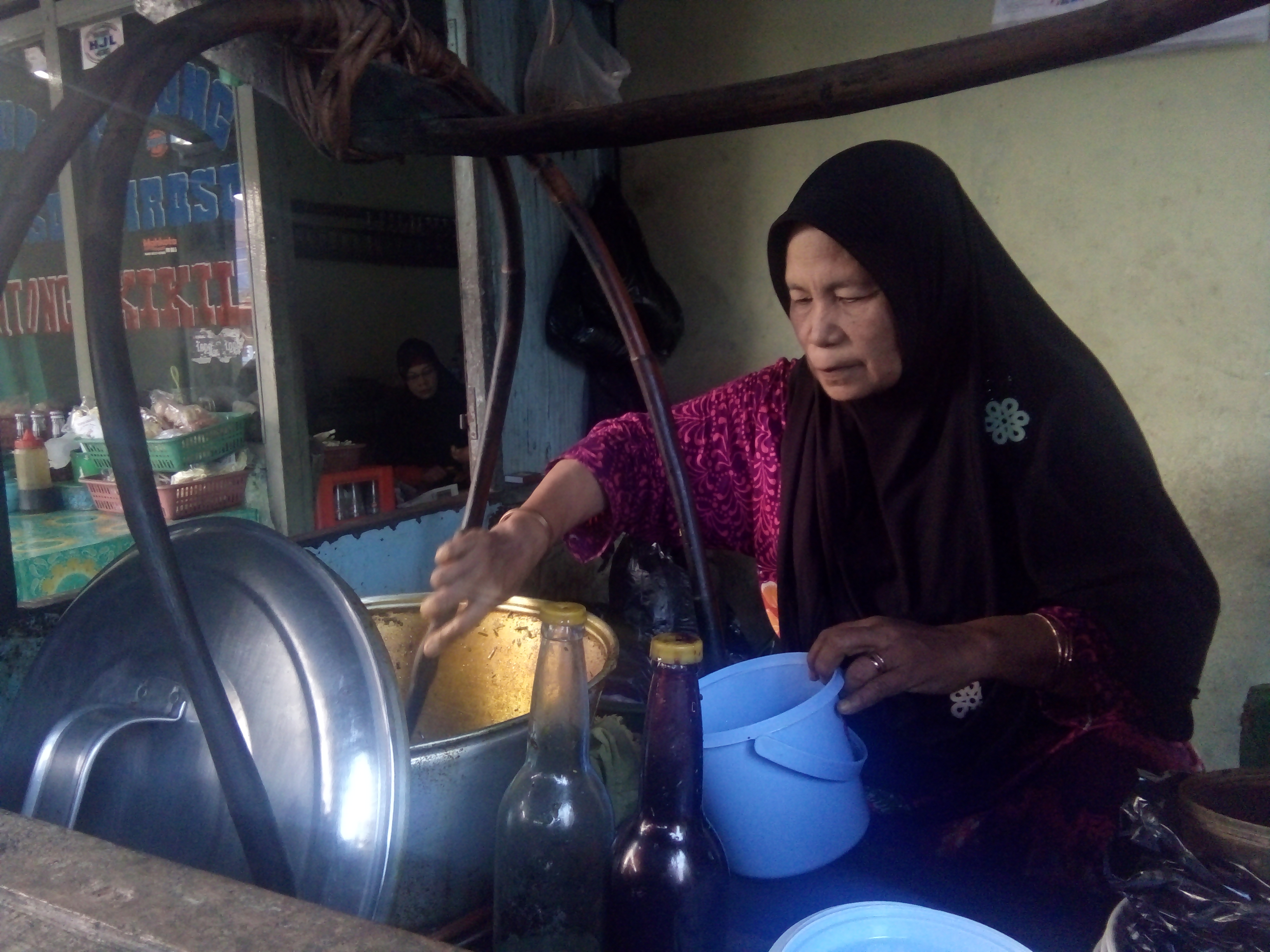 Bu Djumirah sedang ngedoli pelanggan. foto:widikamidi