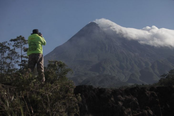 Petugas memantau aktivitas kondisi Gunung Merapi pasca kenaikan status dari normal menjadi waspada dengan radio komunikasi di kawasan Cangkringan, Sleman, DI Yogyakarta, Selasa 22 Mei 2018. (Foto: Antara)