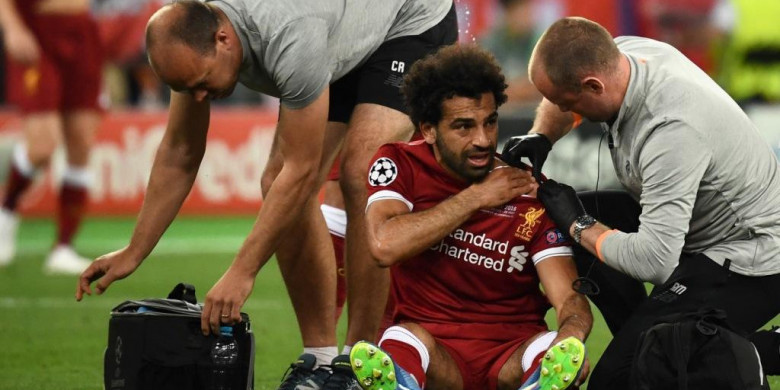 Striker Liverpool, Mohamed Salah, mendapatkan perawatan akibat cedera dalam laga final Liga Champions kontra Real Madrid di Stadion NSC Olimpiyskiy, Kiev, Ukraina pada 26 Mei 2018. (Foto: AFP)