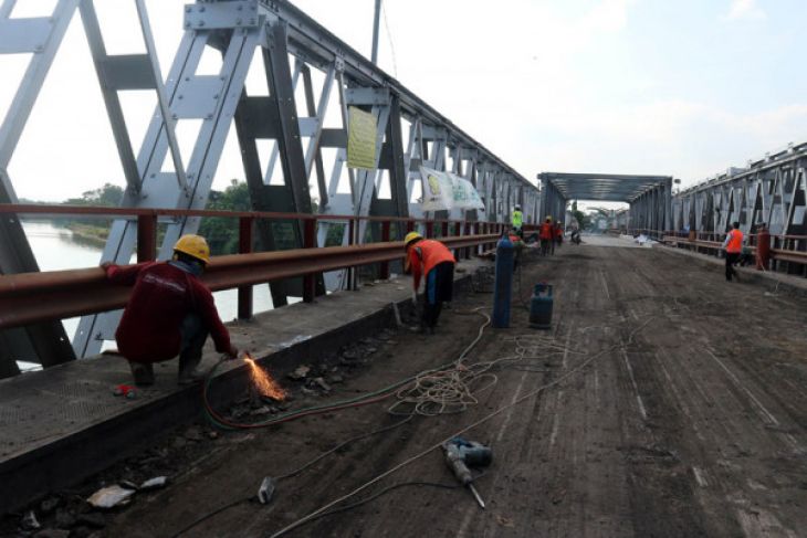 Sejumlah pekerja menyelesaikan perbaikan jembatan Widang di Kecamatan Widang, Tuban, Jawa Timur, yang ambruk,  pada April lalu. Balai Besar Pelaksanaan Jalan Nasional (BBPJN) VIII Surabaya akan memfungsikan jembatan Widang bagian timur itu pada 3 Juni tapi hanya untuk kendaraan ringan. (Foto: Antara)