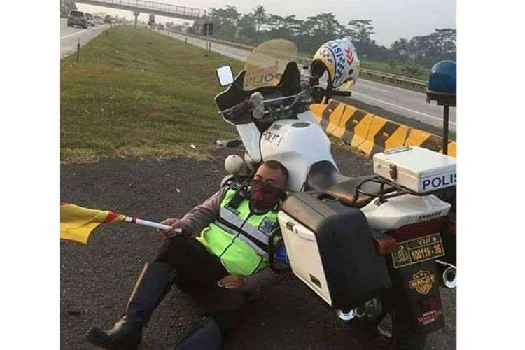 Bripka Wawan Somantri lelah setelah seharian mengatur lalu lintas di Tol Cipali, Jawa Barat.