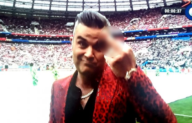 Robbie Williams mengacungkan jari tengah saat menyanyi di acara pembukaan Piala Dunia 2018, Kamis (14/6/2018).