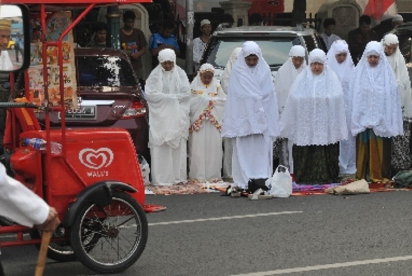 IBADAH: Para pemudik sedang shalat dalam perjalanan. (foto: ist)