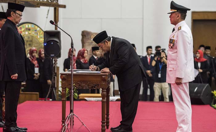 Gubernur Jawa Barat periode 2013-2018 Ahmad Heryawan (tengah) menandatangani surat serah terima jabatan disaksikan Mendagri  Tjahjo Kumolo (kiri) dan PJs.  Gubernur Jawa Barat Komjen Pol M. Iriawan (kanan) di Gedung Merdeka, Bandung, Jawa Barat, Senin 18 Juni 2018.  (foto: m. agung rajasa/antara)