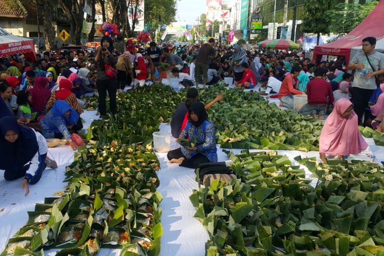 Ribuan pincuk nasi pecel yang disajikan Pemkot Madiun memecahkan rekor MURI hingga rekor dunia memperingati satu abad kota itu dii Jalan Pahlawan‎ Kota Madiun, Jumat 22 Juni 2018. (Foto: Kompas)