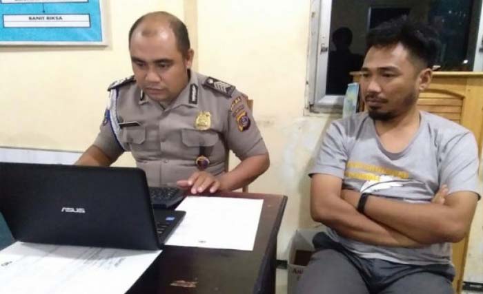  Ketua AJI Palu sekaligus Pemimpin Redaksi Radar TV Palu, Muhammad Iqbal (kanan)  saat memberi keterangan kepada penyidik Propam Polda Sulteng, hari Minggu 24 Juni 2018.  (foto: patar/antara)