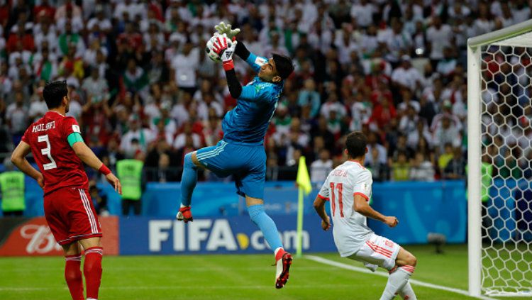 Kiper Iran Alireza Beiranvand memetik bola di udara. 