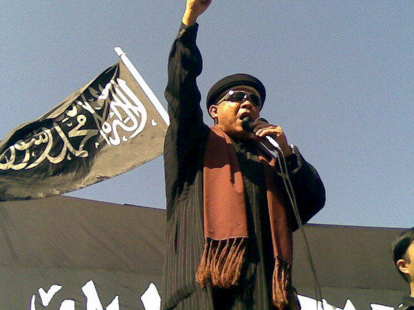 Ustad Hari Moekti dengan background bendera HTI.