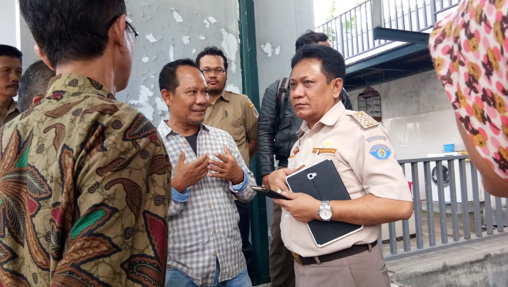 Pemilik ikan Gopur, berbaju kotak=kotak saat dimintai keterangan petugas. (Foto: Prigi Arisandi/Ecoton)
