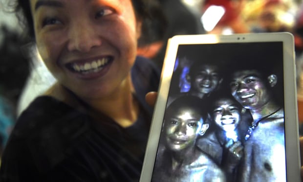 Orang tua korban menunjukkan foto putranya yang masih hidup dalam gua. 