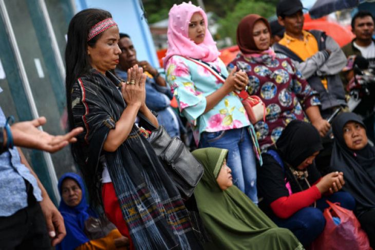 Keluarga korban tenggelamnya KM Sinar Bangun bersama warga mengikuti doa lintas agama di dermaga Tigaras, Danau Toba, Simalungun, Sumatera Utara, Minggu 1 Juli 2018. Doa yang dipimpin sejumlah pemuka agama secara bergantian tersebut bertujuan agar para jenazah korban KM Sinar Bangun segera ditemukan dan operasi SAR yang dilakukan oleh tim gabungan dapat berlangsung dengan lancar. (Foto: Antara) 