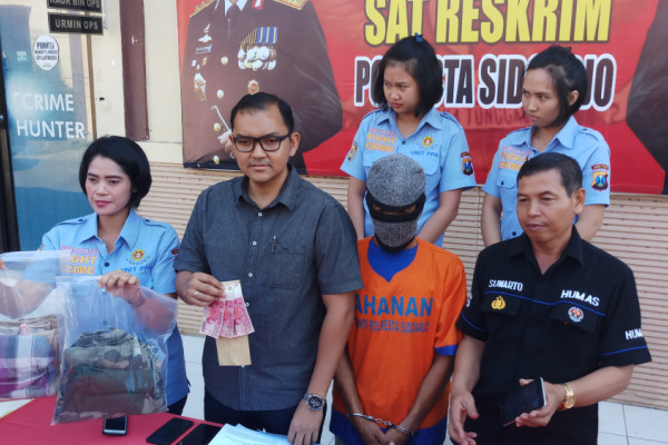 Petugas Satreskrim Polresta Sidoarjo menunjukkan barang bukti pelaku perdagangan orang, Selasa 10 Juli 2018.  (Foto: Antara)