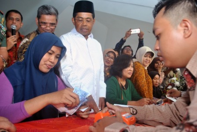 Menteri Sosial Idrus Marham (tengah) bersama Bupati Bogor Nurhayanti (ketiga kanan) menyaksikan pencairan dana bantuan saat Penyaluran Bantuan Sosial Program Keluarga Harapan (PKH) dan Bantuan Sosial Pangan Beras Sejahtera (Bansos Rastra) di Gedung Tegar Beriman, Cibinong, Kabupaten Bogor, Jawa Barat. (Foto: Antara)