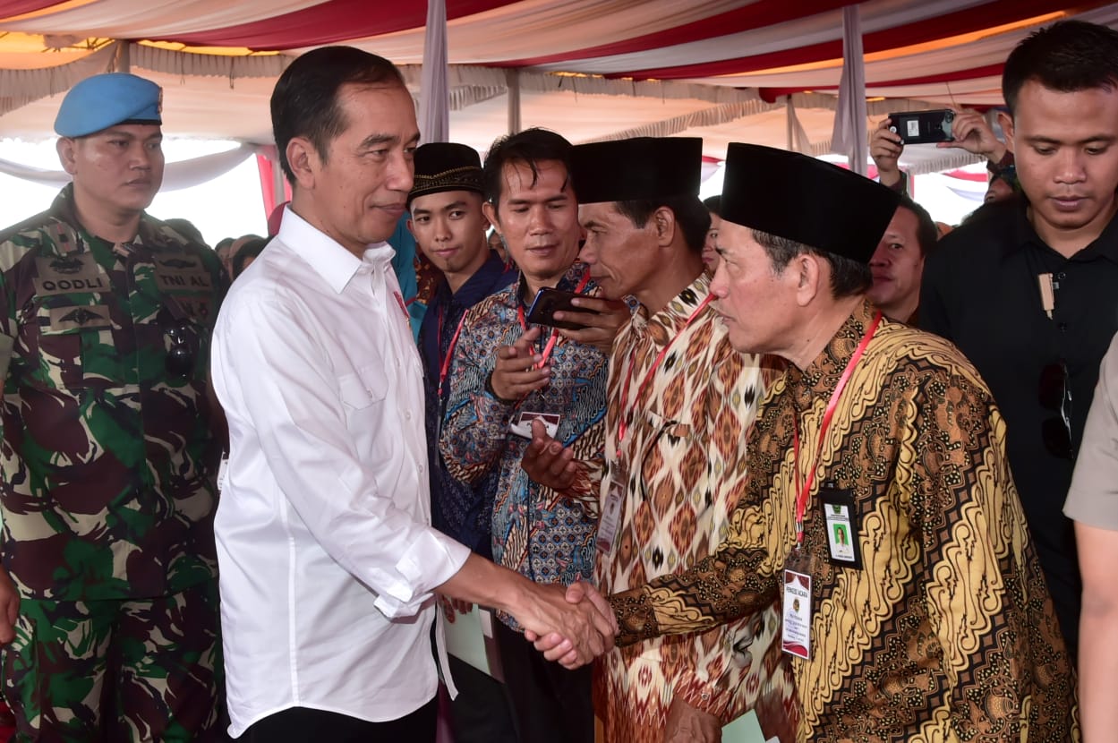 Jokowi bersalaman dengan peserta program padat karya tunai (PKT) di Banyuasin