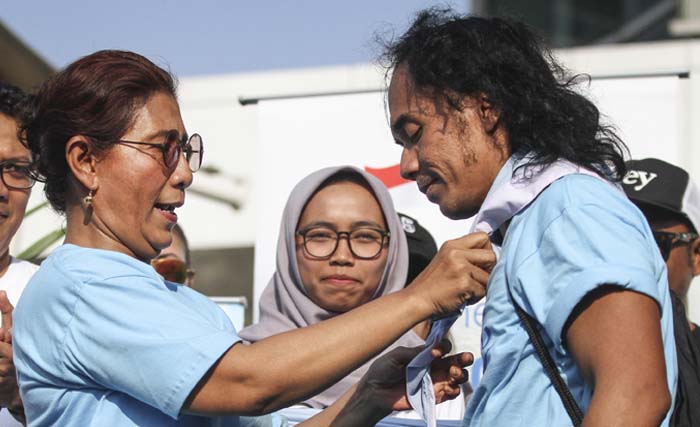 Menteri Kelautan dan Perikanan Susi Pudjiastuti menyematkan syal kepada musisi grup band Slank Kaka (kanan) saat meresmikan Pandu Laut Nusantara di kawasan Bundaran HI, Jakarta, Minggu 15 Juli 2018.  (foto:dhemas reviyanto/antara)