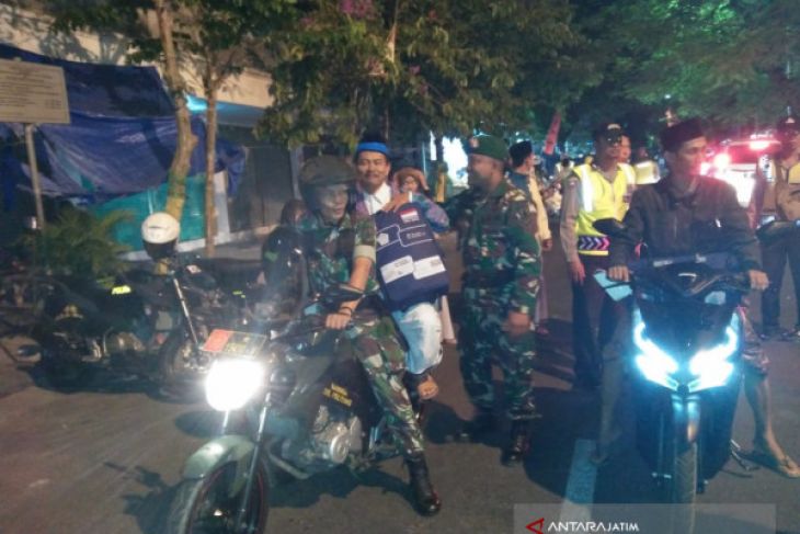 Anggota Kodim 0826 Pamekasan jadi tukang ojek dadakan menjemput calon jamaah haji di tempat parkir. (Foto: Antara)