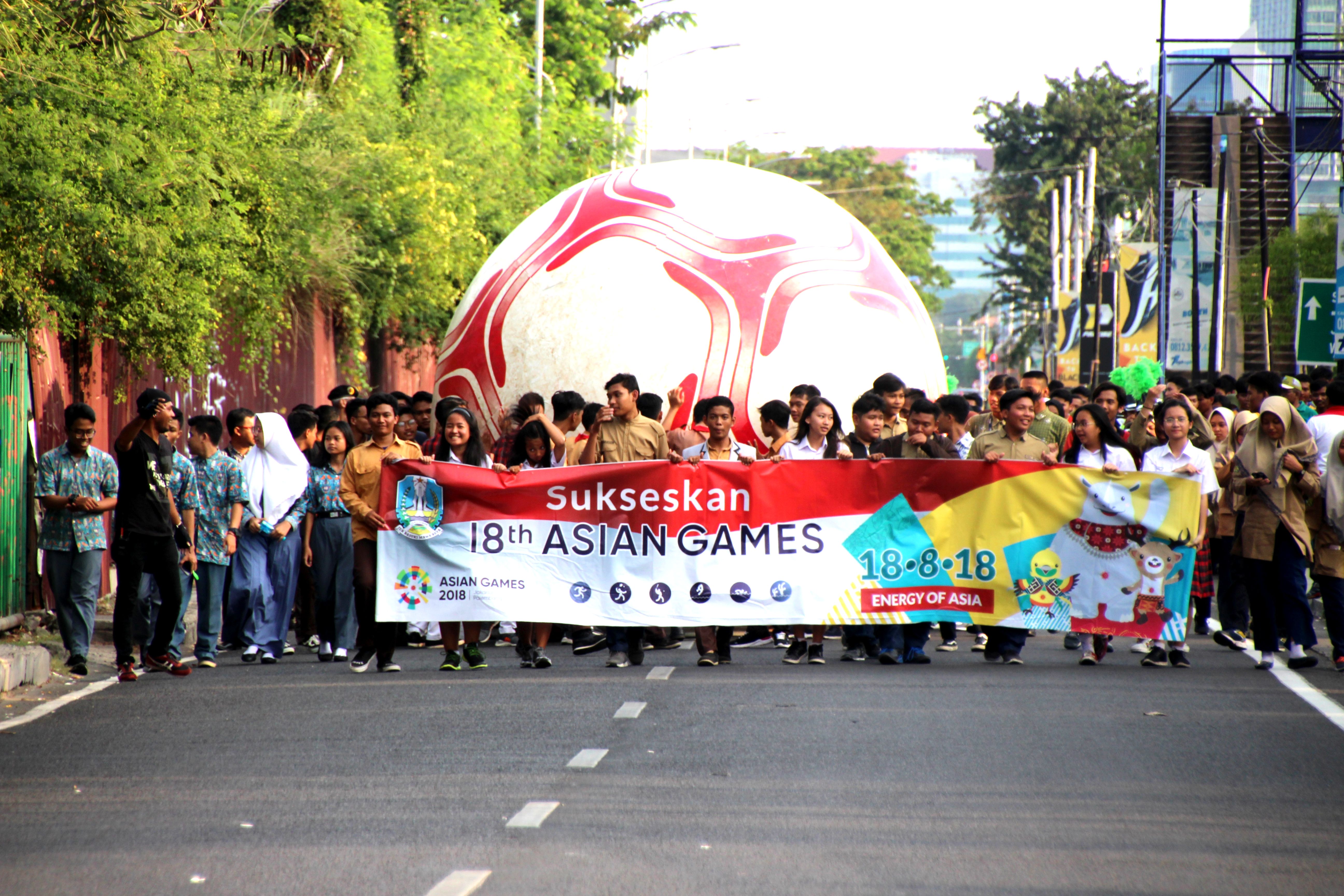 Arak-arakan penggelindingan bola raksasa seremonial countdown Asian Games ke-18 di Frontage Road Timur, Jalan Ahmad Yani, Surabaya, Sabtu, 21 Juli 2018. (Foto: Farid/ngopibareng.id) 