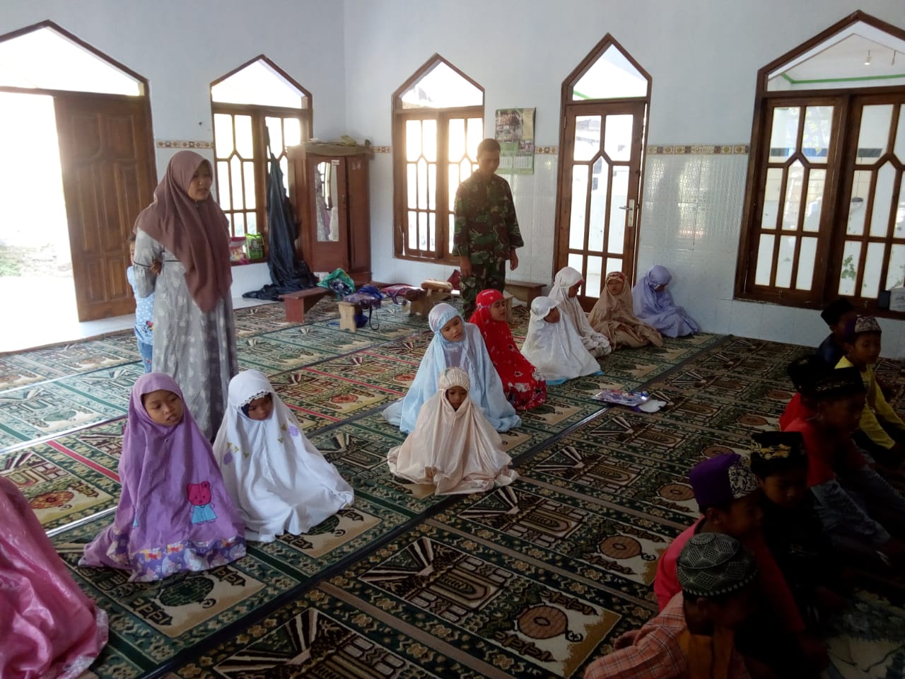 Prajurit Satgas TMMD Kodim 0815 Mojokerto Peltu Imam Bahrudin Bantu Ajari Siswa-Siswi TPQ Tata Cara Shalat