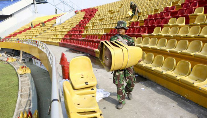 Anggota TNI dari satuan Yon Zikon 12/Karana Jaya memanggul kursi yang rusak akibat ulah oknum suporter Sriwijaya FC di tribun utara Stadion Gelora Sriwijaya Jakabaring (GSJ), Palembang, Sumatera Selatan, Senin 23 Juli 2018. Sebanyak 711 kursi di tribun utara dan selatan stadion Gelora Sriwijaya Jakabaring (GSJ) Palembang, rusak oleh oknum suporter Sriwijaya. (Foto: Antara)