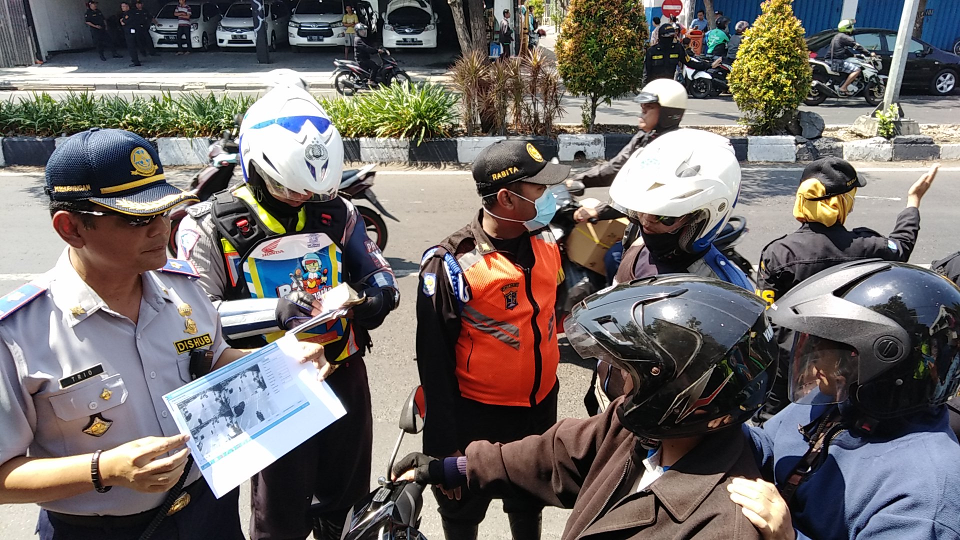 Petugas Dinas Perhubungan dan polisi lalu lintas Polrestabes Surabaya menilang berdasarkan pantauan CCTV. Ujicoba ini  dilaksanakan di persimpangan Kertajaya-Dharmawangsa, Surabaya, Kamis, 26 Juli 2018. (Foto: Farid/ngopibareng.id) 