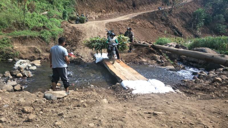 Salah Satu Petani Ladang Sedang Melintasi Jembatan Darurat Di Lokasi TMMD