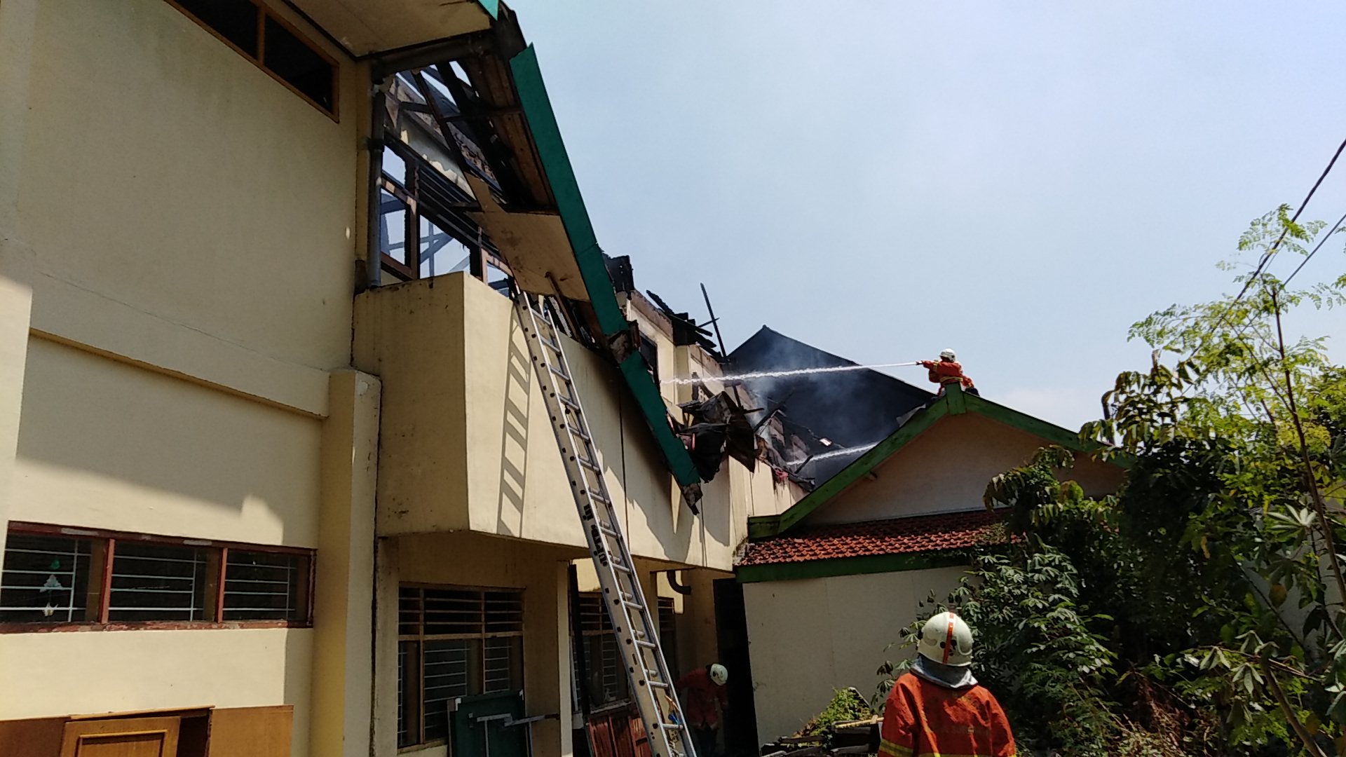 Petugas pemadam kebakaran lakukan penanganan di SMPN 21, Surabaya, Senin, 6 Agustus 2018. (foto: farid /ngopibareng.id) 