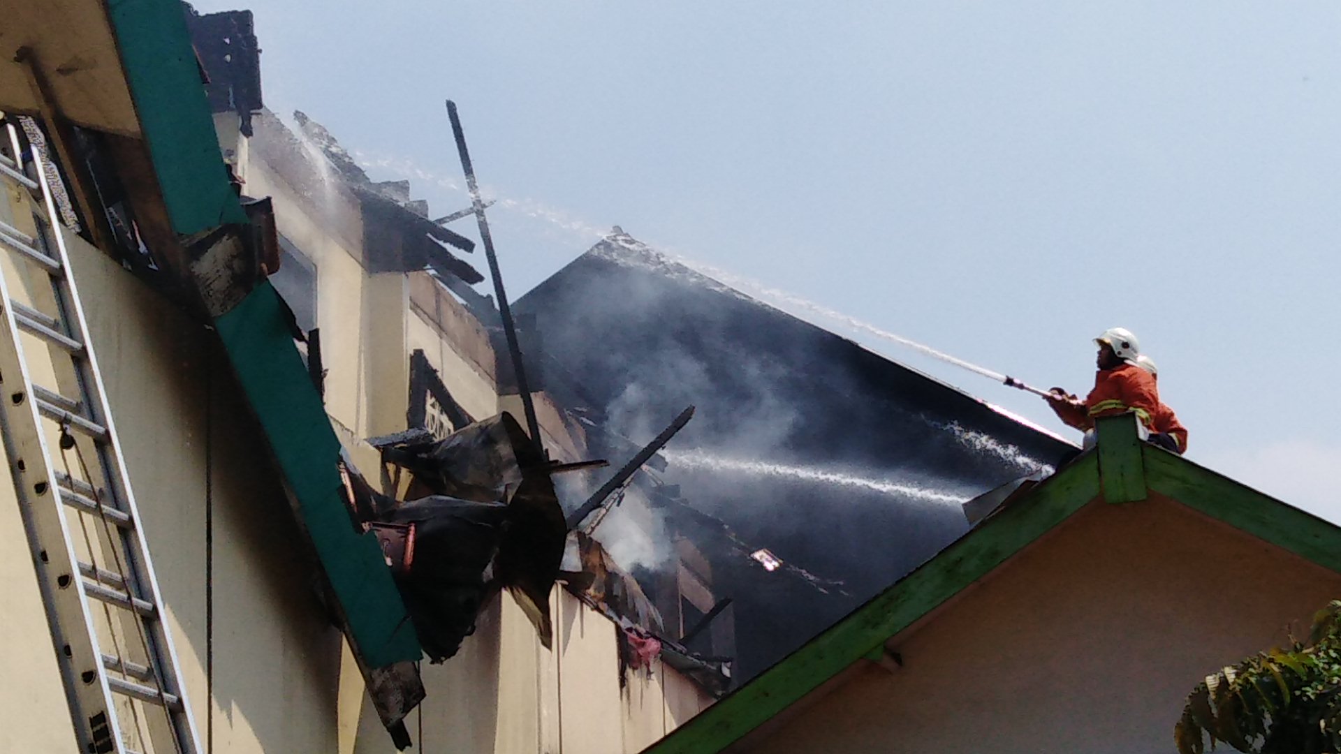 Petugas pemadam kebakaran lakukan penanganan di SMPN 21, Surabaya, Senin, 6 Agustus 2018. (Foto: Farid/ngopibareng.id) 