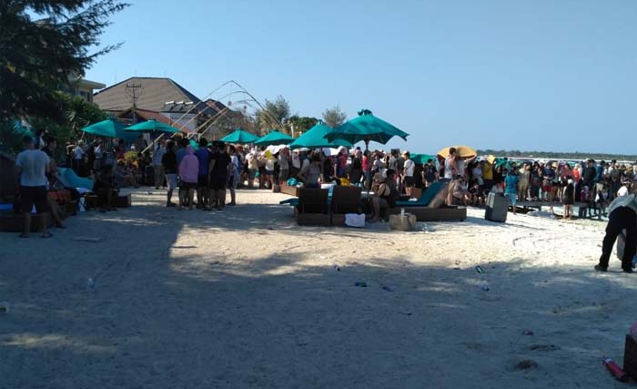 Ratusan wisatawan asing dan domestik antri untuk dievakuasi di Gili Terawangan, NTB, hari Senin 6 Agustus sore. (foto: rahmad hendro/ngopibareng)