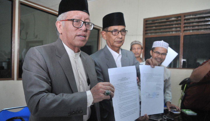 Ketua Majelis Ulama Indonesia (MUI) Provinsi Sumatera Selatan Prof. Aflatun Muchtar (kiri) didampingi Sekretaris Umum MUI Sumsel Ayik Farid (kedua kiri) menunjukkan surat imbauan kepada Dinas Kesehatan Sumsel di kantor LPPOM MUI Sumsel, Palembang, Senin 6 Agustus 2018. MUI Sumsel mengimbau penundaan pelaksanaan imunisasi Campak-Measles Rubella (MR) di Provinsi Sumsel hingga diperoleh kejelasan kandungan vaksinnya. (Foto: Antara)