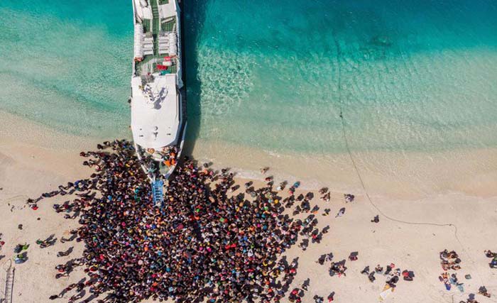 Sebuah kapal dikerubuti para wisatawan manca dan domestik untuk mengevakuasi mereka dari  Gili Terawangan, NTB hari Selasa 7 Agustus lalu. (foto: mellisa/afp)