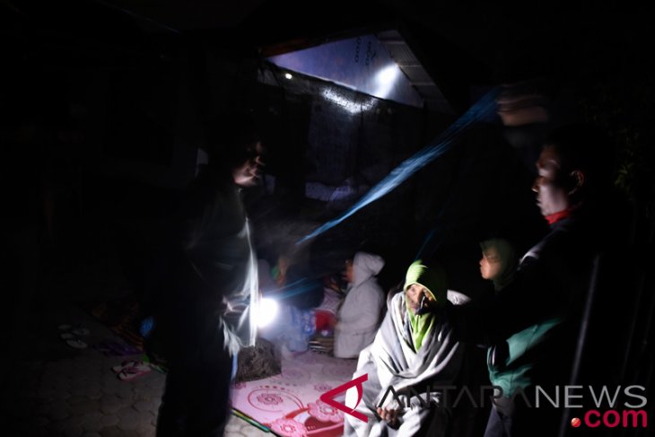 Warga membuat tenda dan memilih tetap berada di luar rumah pascagempa di Ampenan, Mataram, NTB, Minggu (19/8/2018). Gempa bumi berkekuatan 7 Skala Richter kembali mengguncang Lombok pada Minggu malam pukul 22.56 Wita yang berpusat di timur laut Lombok Timur pada kedalaman 10 km. (Foto: Antara)