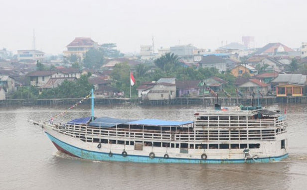 Kapal angkut barang melintasi Sungai Kapuas yang diselimuti kabut asap yang berasal dari kebakaran lahan gambut, di Pontianak, Kalbar, Kamis 16 Agustus 2018. BNPB menyatakan bahwa dari hasil pantauan satelit per 16 Agustus, terdapat 1.061 hotspot (titik panas) akibat karhutla yang tersebar di sejumlah kabupaten/kota di Kalbar yang menimbulkan kabut asap di wilayah Kota Pontianak. (Foto: Antara)