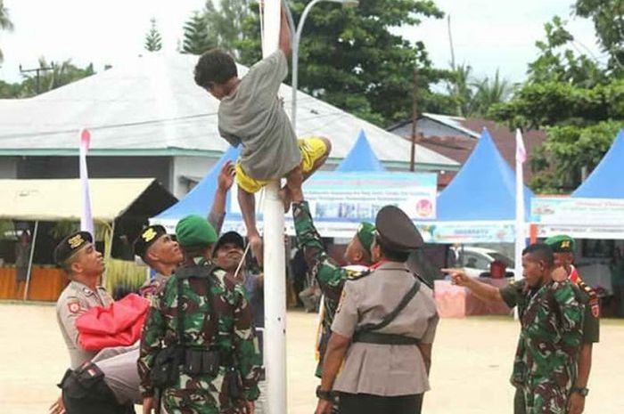 Aksi Resa Magar memanjat tiang bendera saat HUT ke-14 Kabupaten Kepulauan Aru. Foto: FB Karel Ridolof Labok.