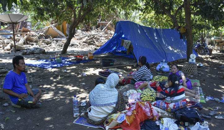 Sejumlah warga beristirahat dekat rumahnya yang roboh pascagempa di Dusun Labuan Pandan, Desa Padak Guar, Kecamatan Sambelia, Lombok Timur, NTB, Senin 20 Agustus 2018. (Foto: Antara)